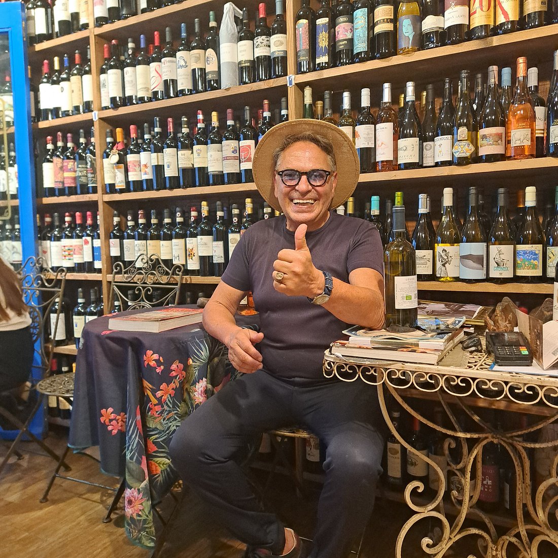 Leonardo, the owner of Antiche Dogane, sitting in the wine shop and giving a thumbs-up