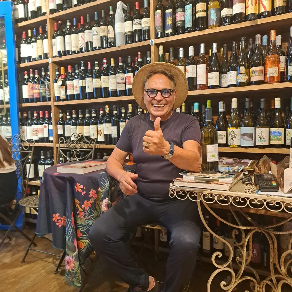 Leonardo, the owner of Antiche Dogane, sitting in the wine shop and giving a thumbs-up